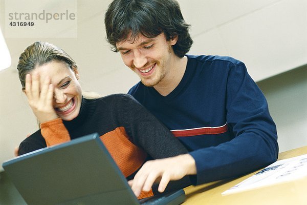 Paar mit Laptop  lachend