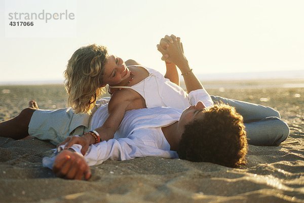 Teenagerpaar am Strand liegend