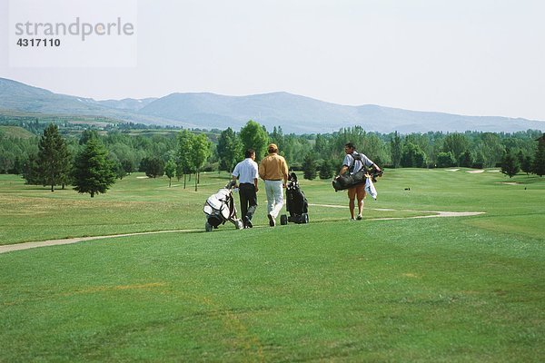 Golfer  die über den Golfplatz laufen  Rückansicht