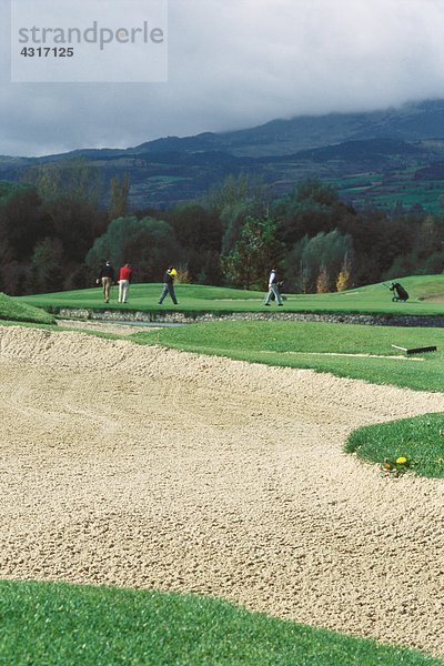 Golfer auf dem Golfplatz  Sandfang im Vordergrund