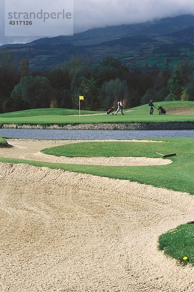 Golfer auf dem Golfplatz  Sandfang im Vordergrund