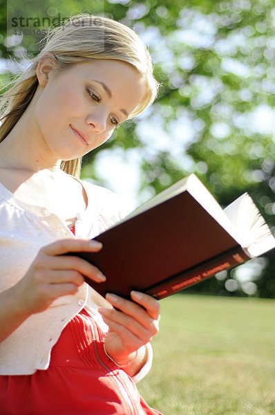 Junge Frau beim Lesen im Freien