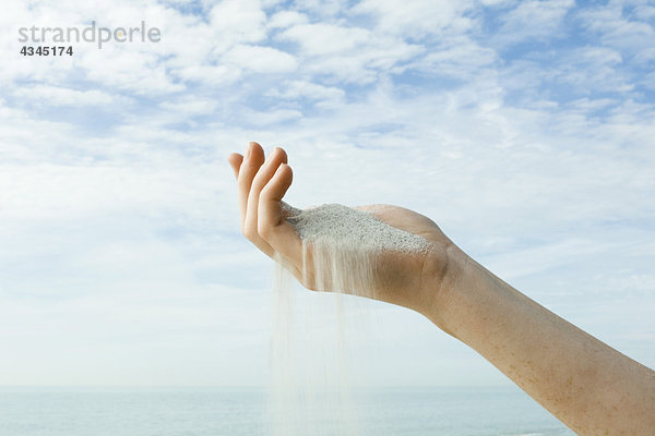 Sand verschüttet aus der hohlen Hand