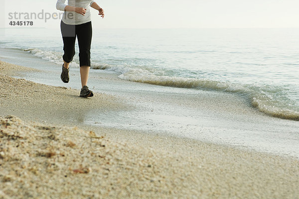 Frau beim Joggen am Strand  niedrige Sektion