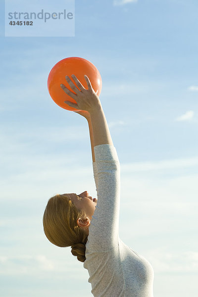 Frau beim Dehnen mit Fitnessball