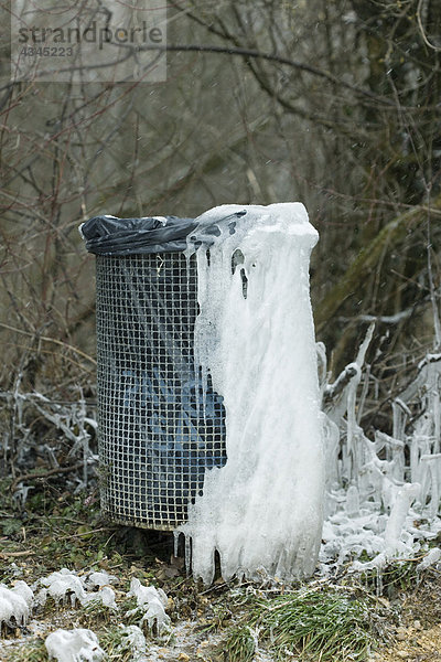 Eis gesammelt auf der Mülltonne im Park