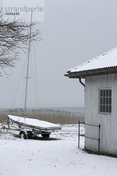 Segelboot an Land in winterlicher Umgebung