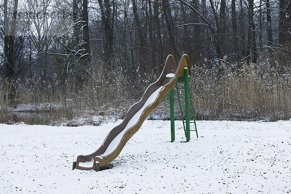 Schneebedeckte Spielplatzrutsche