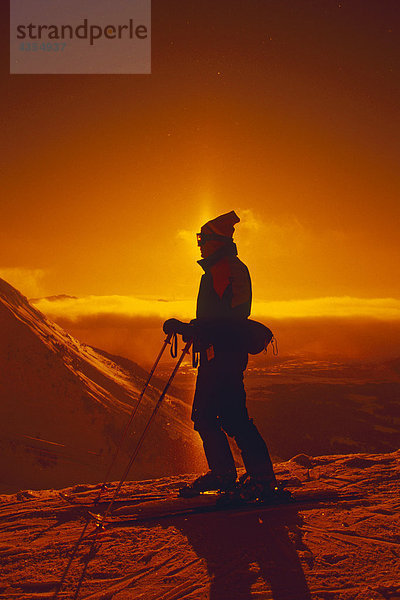 Skifahrer Silhouetted w/Sun Dog auf Mt Alyeska SC AK Winter Backlit