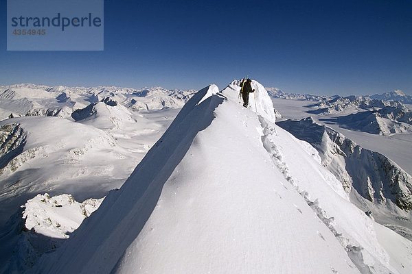 Männlich Heli-Skifahrer steht auf auf dem Schnee bedeckten Bergrücken mit Blick auf Chugach Mtn Bereich SC Alaska Winter