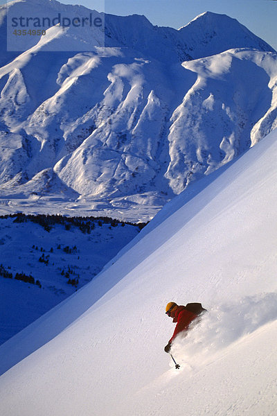 Extremskifahrer Ski down steilen Schnee bedeckt Berg Chugach Mountains South Central Alaska Winter