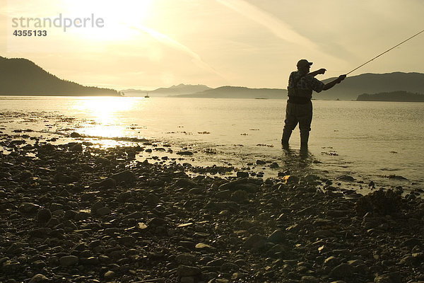 Mann fliegenfischend Küstenlinie von Sitka Sound SE AK Sommer in der Nähe von Hafen Pt Silhouette