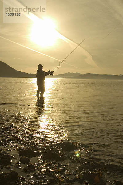 Mann fliegenfischend Küstenlinie von Sitka Sound SE AK Sommer in der Nähe von Hafen Pt Silhouette