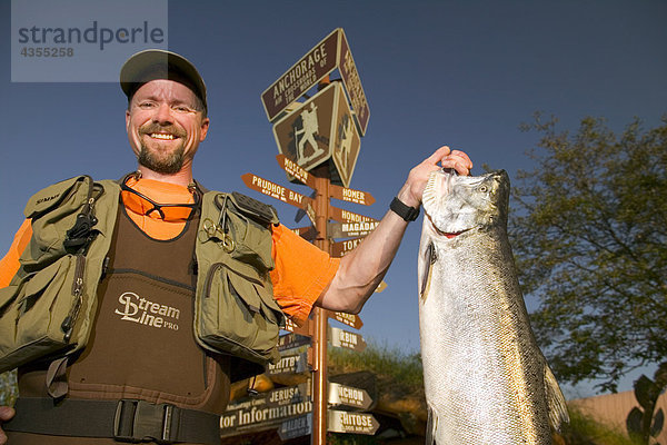 Mann in Fanggeräten hält König Lachs @ ACVB Digital AK SC Sommer Anchorage