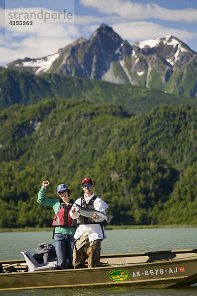 Hält Fischer fing Silber Lachs stehen in einem Boot auf Big River Seen in South Central Alaska im Sommer