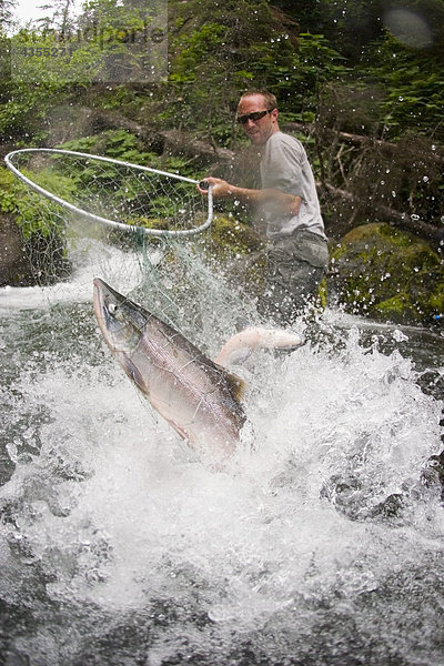 Fischer hält ein Dipnetwith Fisch fing in net China Poot Creek Kenai-Halbinsel in Alaska