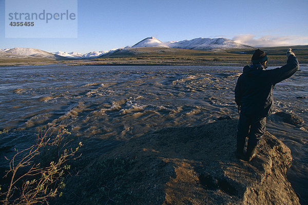 Person steht auf Felsen auf Küstenlinie Kongakut Fluss AK AR Winter