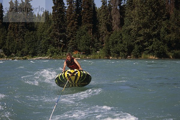 Junge Reiten Innertube hinter Boot auf Kenai River  Kenai-Halbinsel in Alaska Sommer.