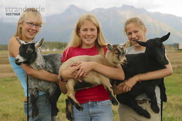 Drei Schwestern halten Ziegen an Alaska State Fair im Mat-Su-Tal in South Central Alaska im Herbst