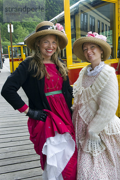 Skagway Straßenbahn Unternehmen Reiseleiter gekleidet in Periode Kostüm Pose neben Straßenbahnen in Skagway  Alaska