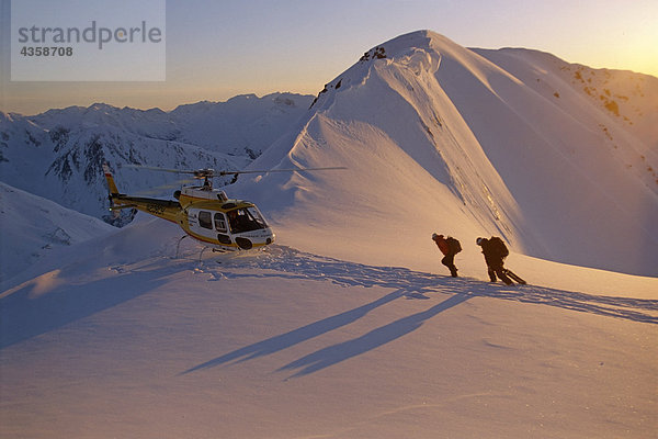 Menschen Wanderung zum Helikopter Schnee bedeckten Ridge @ Sunrise Chugach CT South Central Alaska Winter