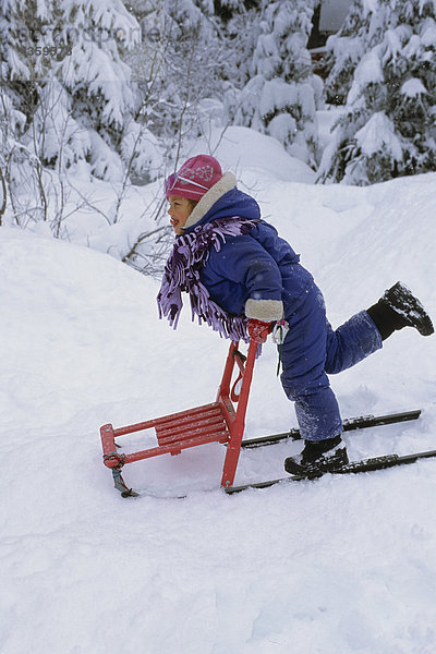 Young Girl Playing auf Tretschlitten im tiefen Schnee SC AK Winter