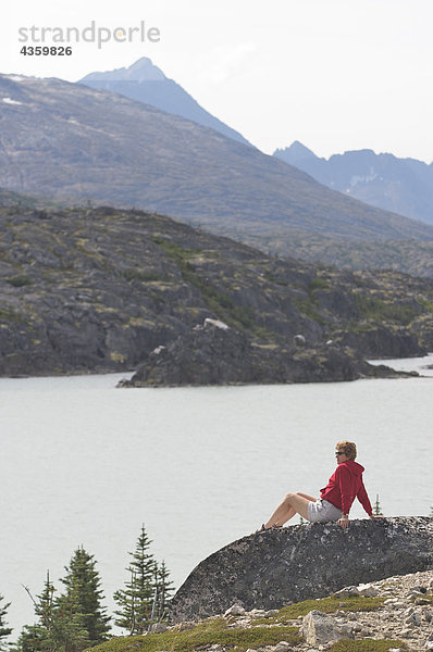 Weibliche Wanderer geniesst eine Sicht Lakeside an den Klondike Gold Rush National Historic Park nördlich von Skagway  Alaska
