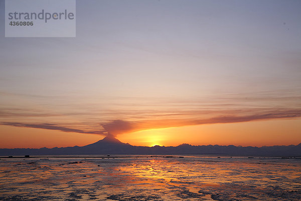 Aschewolke erhebt sich vom Mount Redoubt bei Sonnenuntergang bei Ebbe in der Nähe von Ninilchik  Alaska