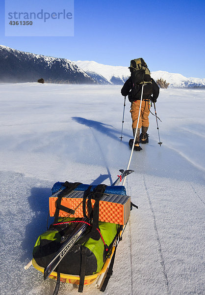 Ansicht des Menschen ziehen ein Gear beladenen Schlitten in 40 mph Winde am Stikine River nahe Punkt Rothsay  Stikine-LeConte Wildnis  Tongass National Forest  Winter  südöstlich  Alaska