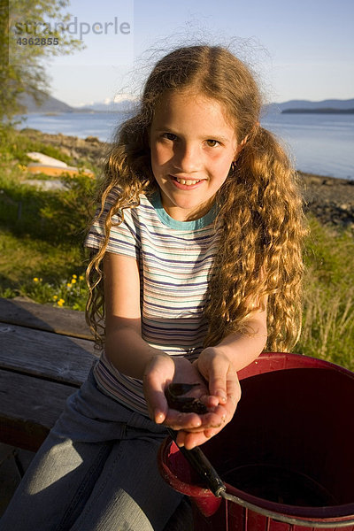 Portrait of young Mädchen hält Muscheln aus kammille am Punkt Louisa Strand nördlich von Juneau südöstlichen Alaska Küste Sommer