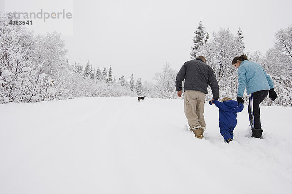 Einige dauern jungen Sohn für eine outdoor Spaziergang im Winter in Pedro Bay  Alaska.