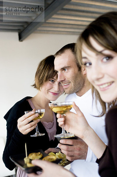 2 Frauen und ein Mann mit Champagnergläsern