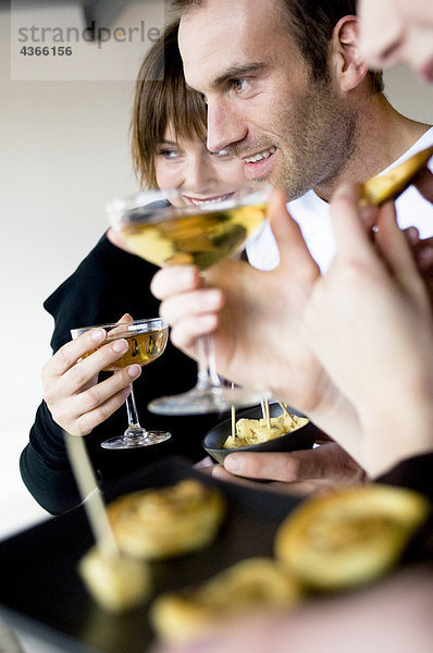 2 Frauen und ein Mann mit einem Glas Champagner