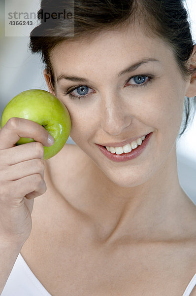Porträt einer jungen Frau beim Apfelessen