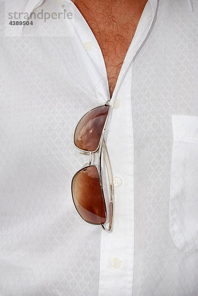 Mann mit Brusthaar  weißem Hemd und Sonnenbrille  mittlerer Ausschnitt
