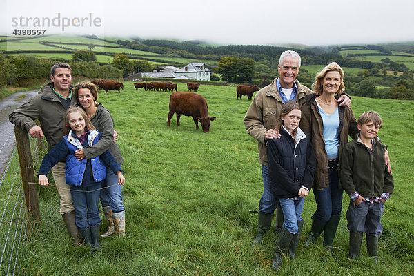 Familie auf dem Bauernhof in einem Feld mit Kühen