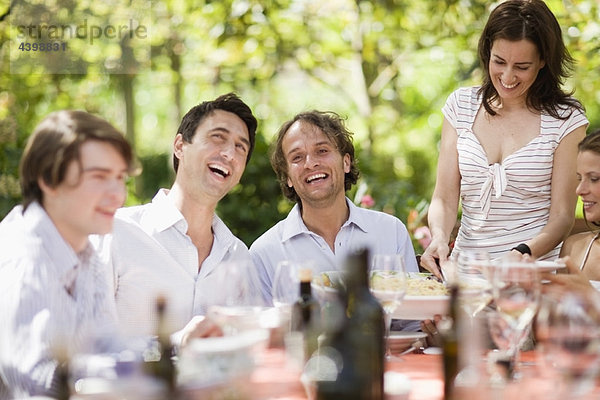 Lachende Menschen auf einem Tisch sitzend
