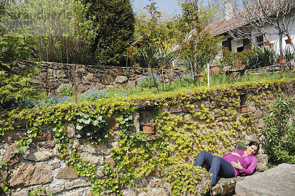 Schwangere entspannt im Frühlingsgarten