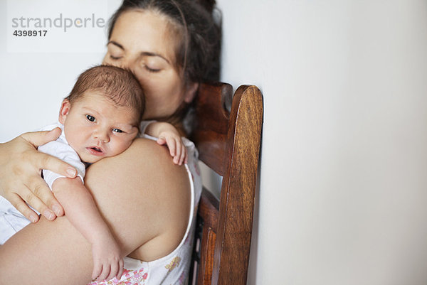 Neugeborenes Baby auf der Schulter der Mutter ruhend