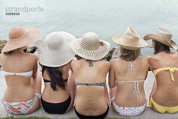 Frauen sitzen zusammen am Ufer des Sees