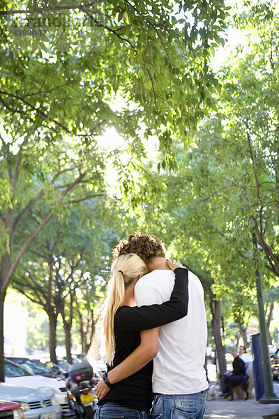 Liebende junge Paare umarmen sich auf der Straße