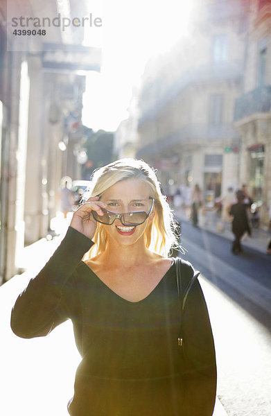 Frau schaut über Sonnenbrille in der Straße