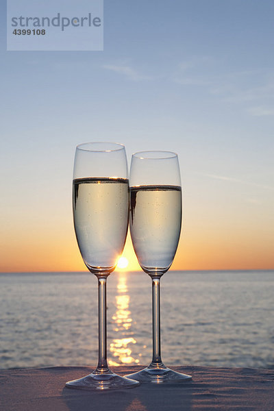 Zwei Gläser Champagner bei Sonnenuntergang