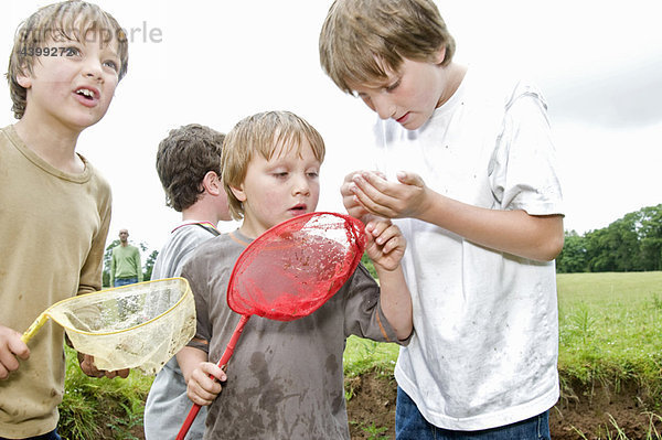 Jungen fischen und fangen einen Fisch