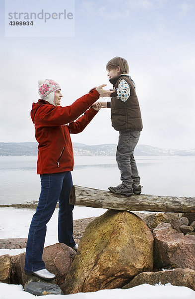 Mutter hilft dem Sohn beim Balancieren