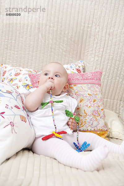 Baby sitzend auf dem Bett