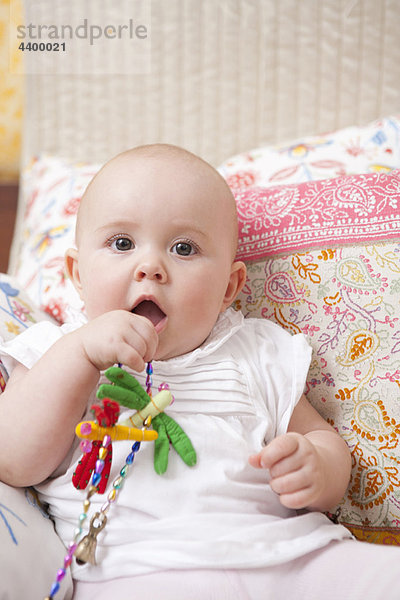 Baby sitzend auf dem Bett