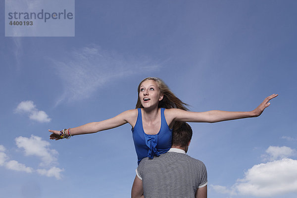 Mädchen fliegt auf den Schultern der Jungen