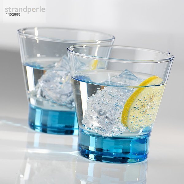 Zwei Gläser Wasser mit Eis und einem Limettenscheibe