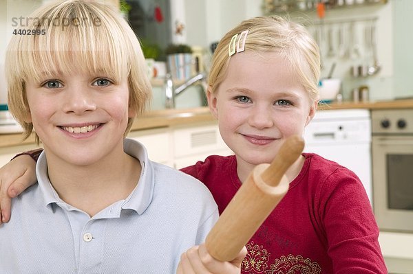 Mädchen und junge mit Nudelholz in einer Küche